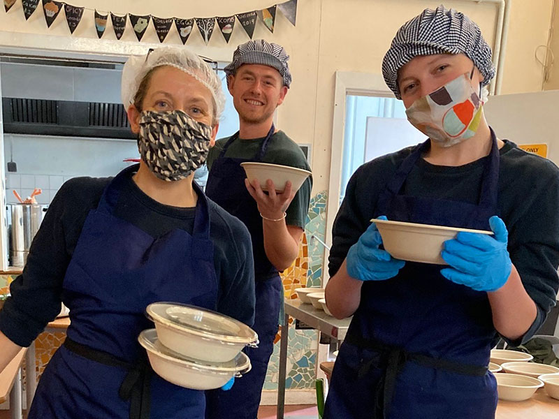 Three people helping at a food kitchen